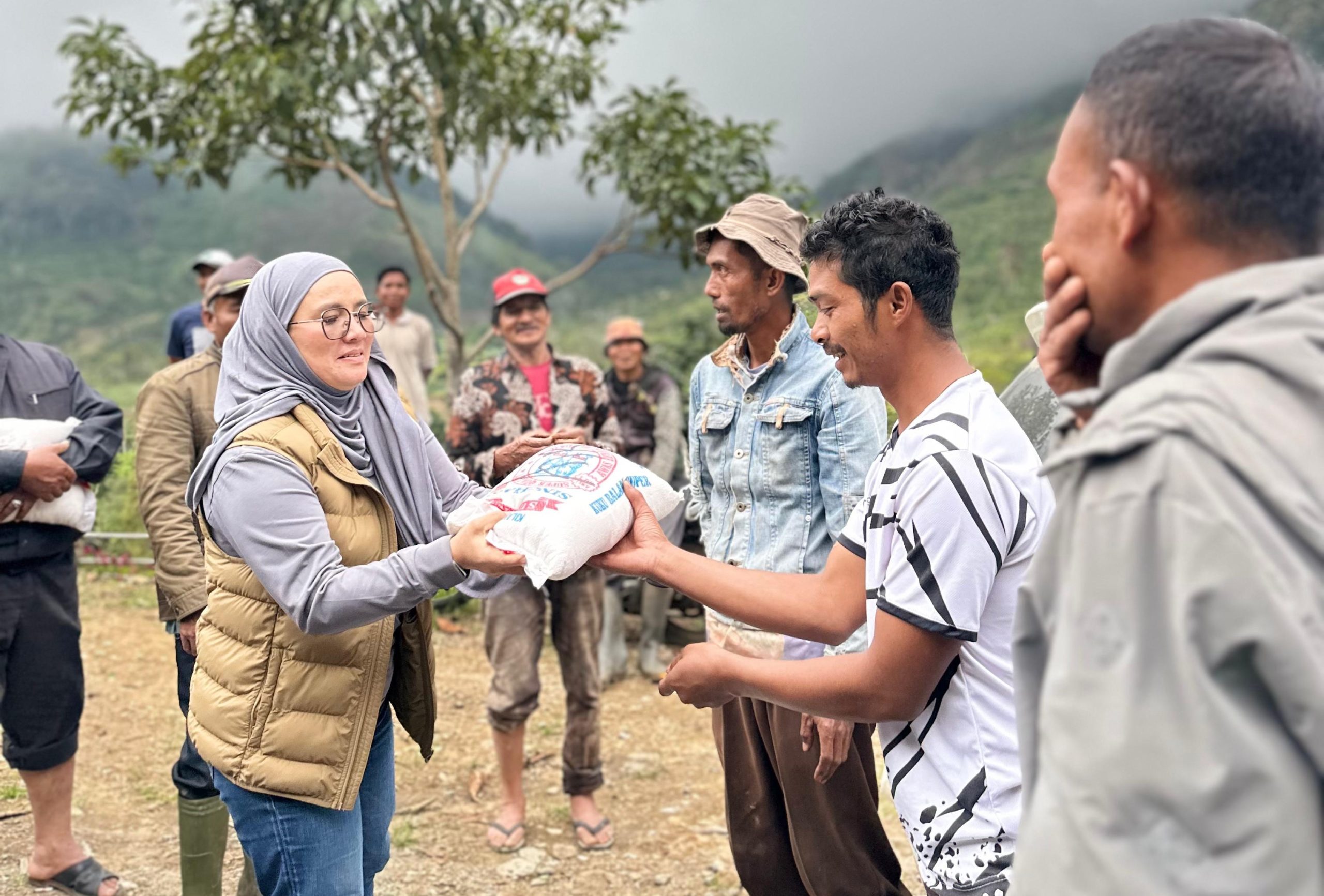 Fitriana memberikan bantuan beras kepada warga